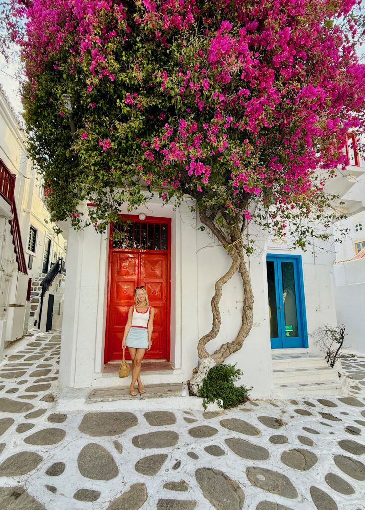 Cobblestone street with boutique shops and travelers in Naousa, Paros