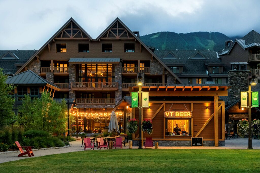 Snow-dusted mountains and ski-in/ski-out luxury at The Lodge at Spruce Peak in Stowe, Vermont – a favorite for Fall & Winter New England Getaways.