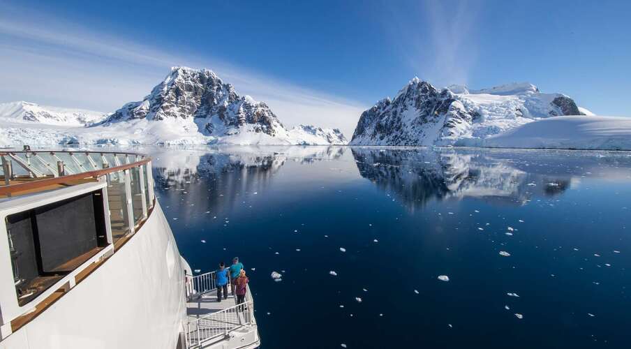 Luxury expedition ship sailing past towering icebergs in Antarctica—the final frontier of luxury exploration.