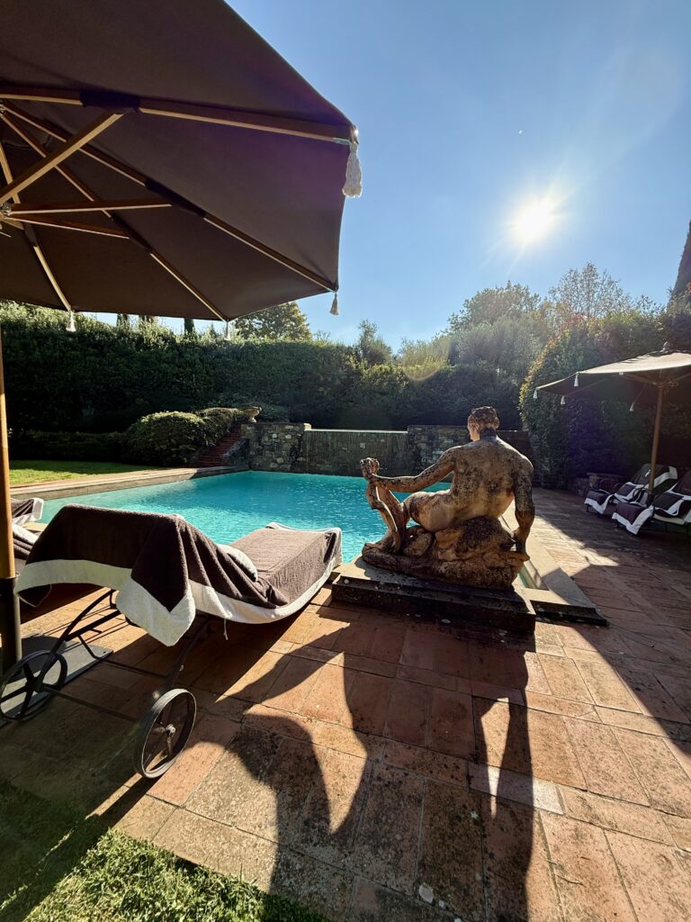 Private pool overlooking the Tuscan countryside surrounded by vineyards and olive trees.